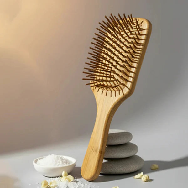 Wooden hair brush by Herbals by SH balanced on grey zen stones.